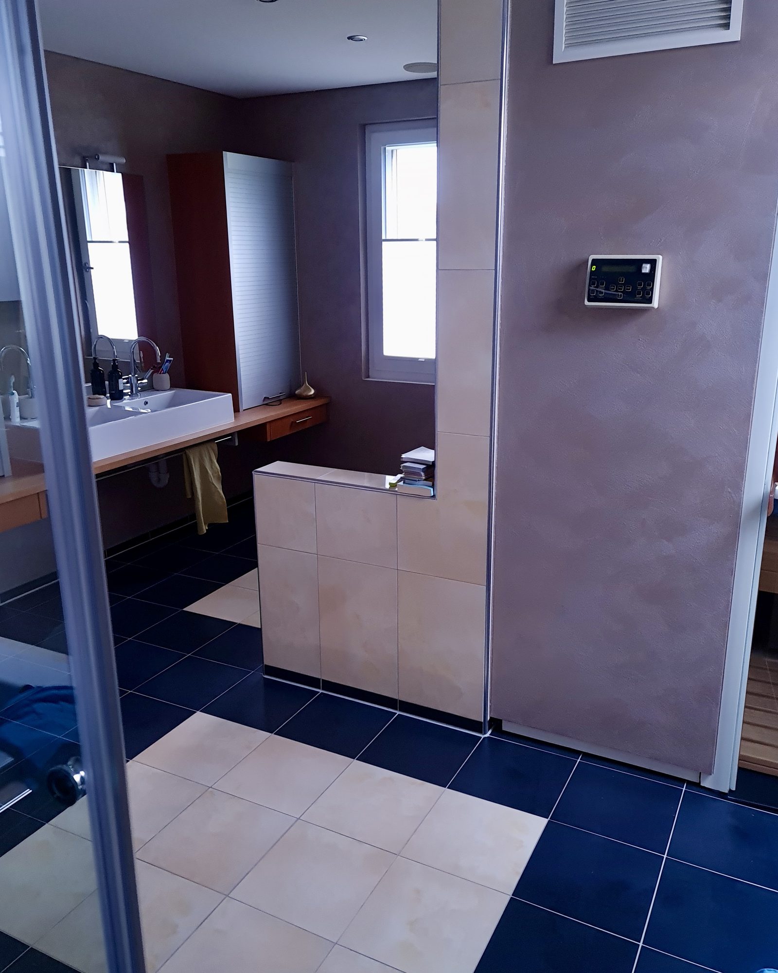 Badezimmer vor der Sanierung mit dunklen Bodenplatten