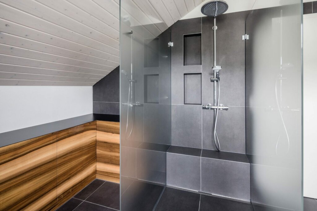 Bodenebene Dusche mit Rinne und Glaswand unter der Dachschräge, Badsanierung Winterthur